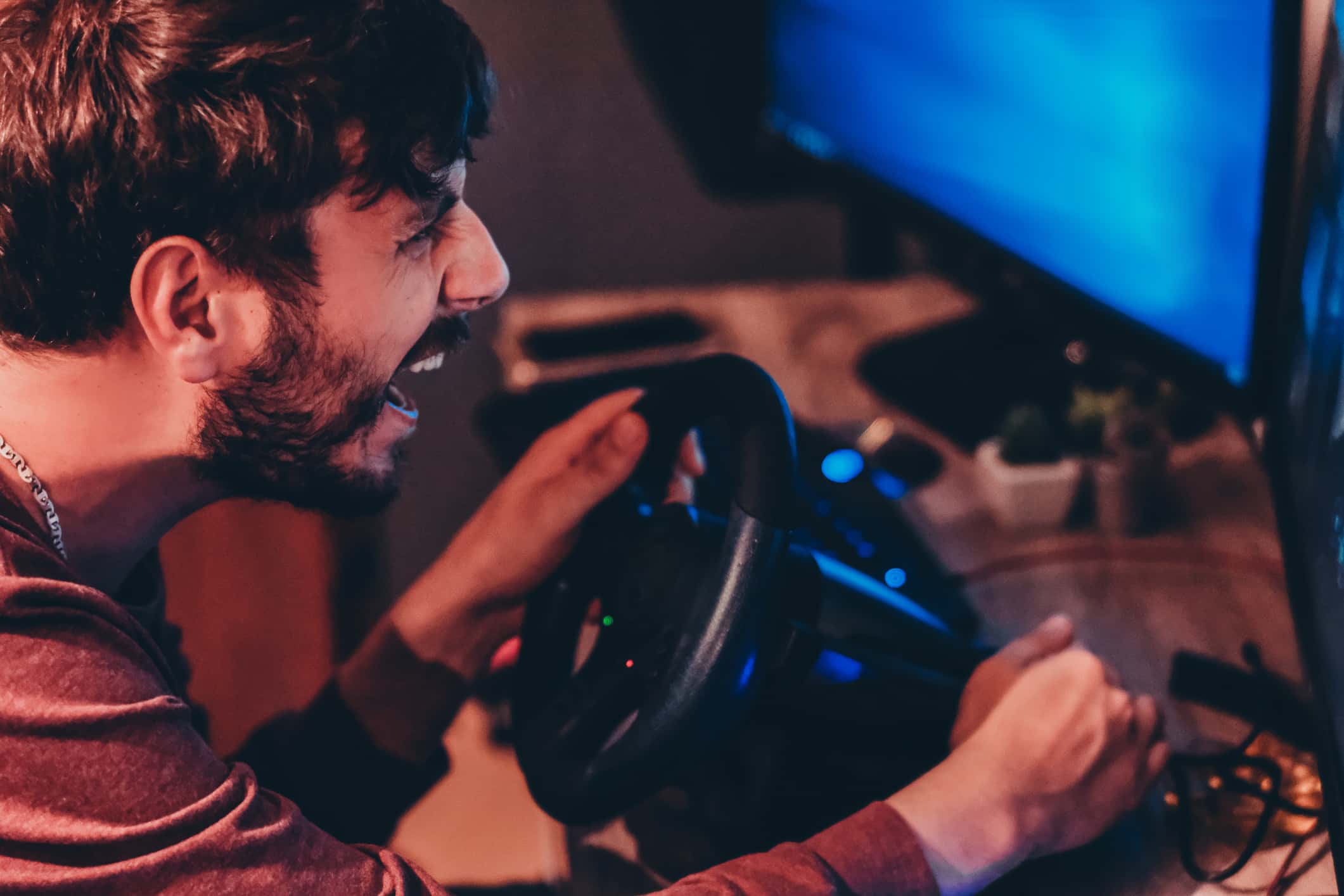 Man playing car racing video game at home.