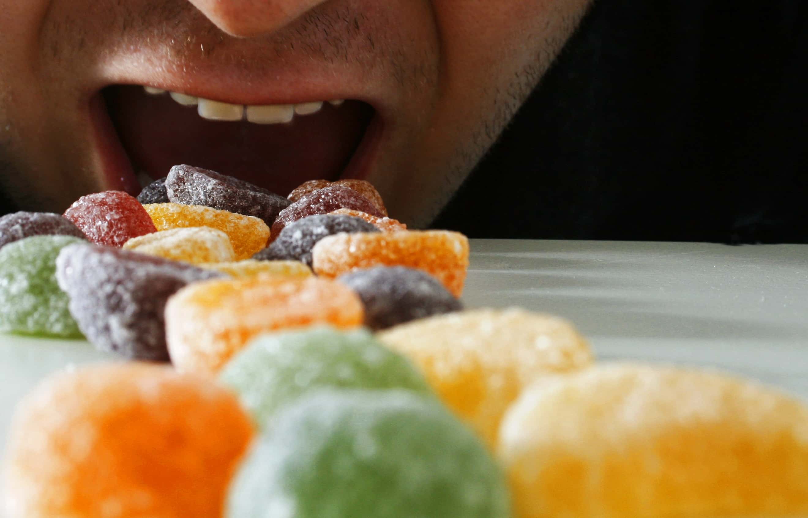 Cropped Image of Hungry Man Eating Fruit Pastilles.