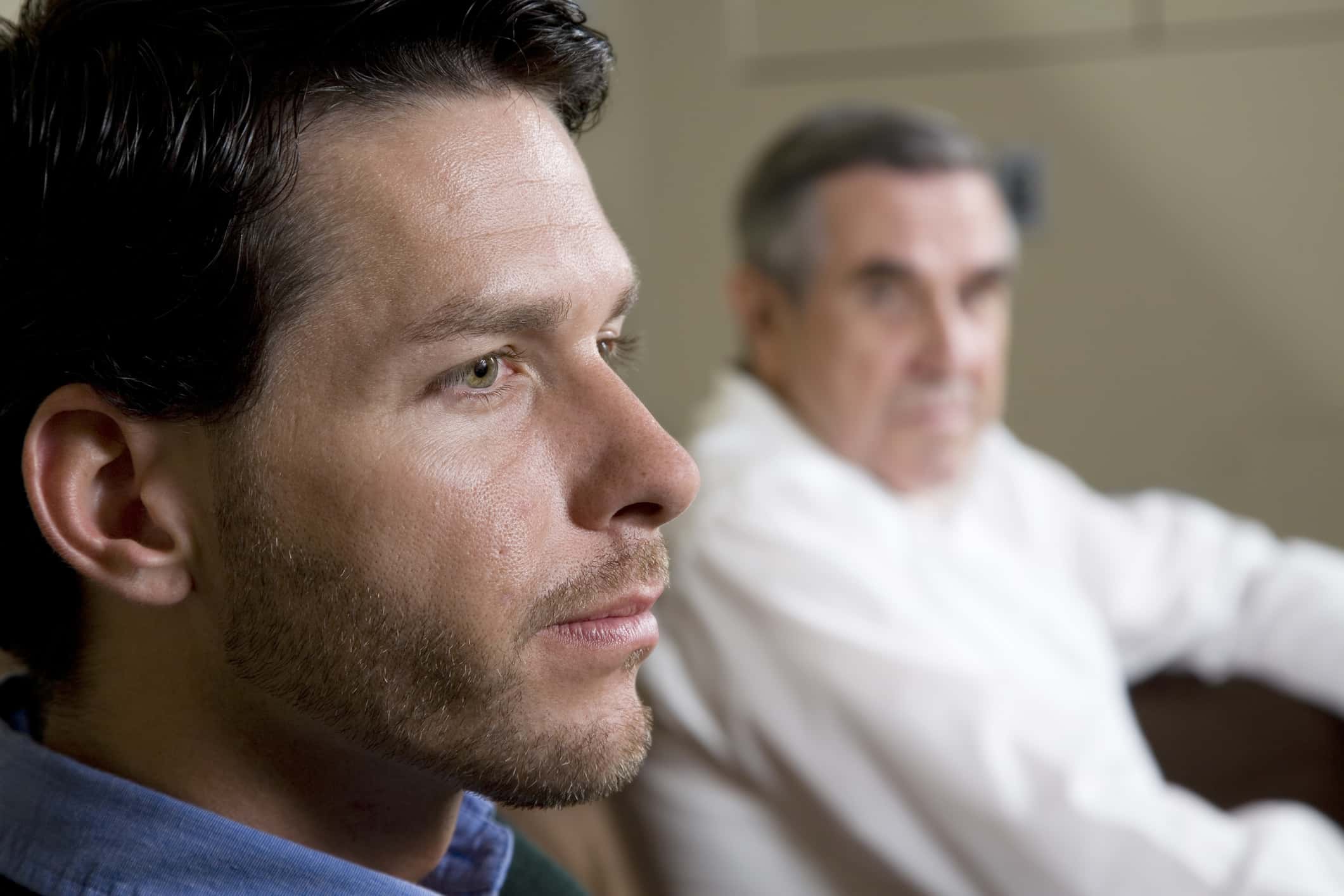 Close-up of man with father looking on.