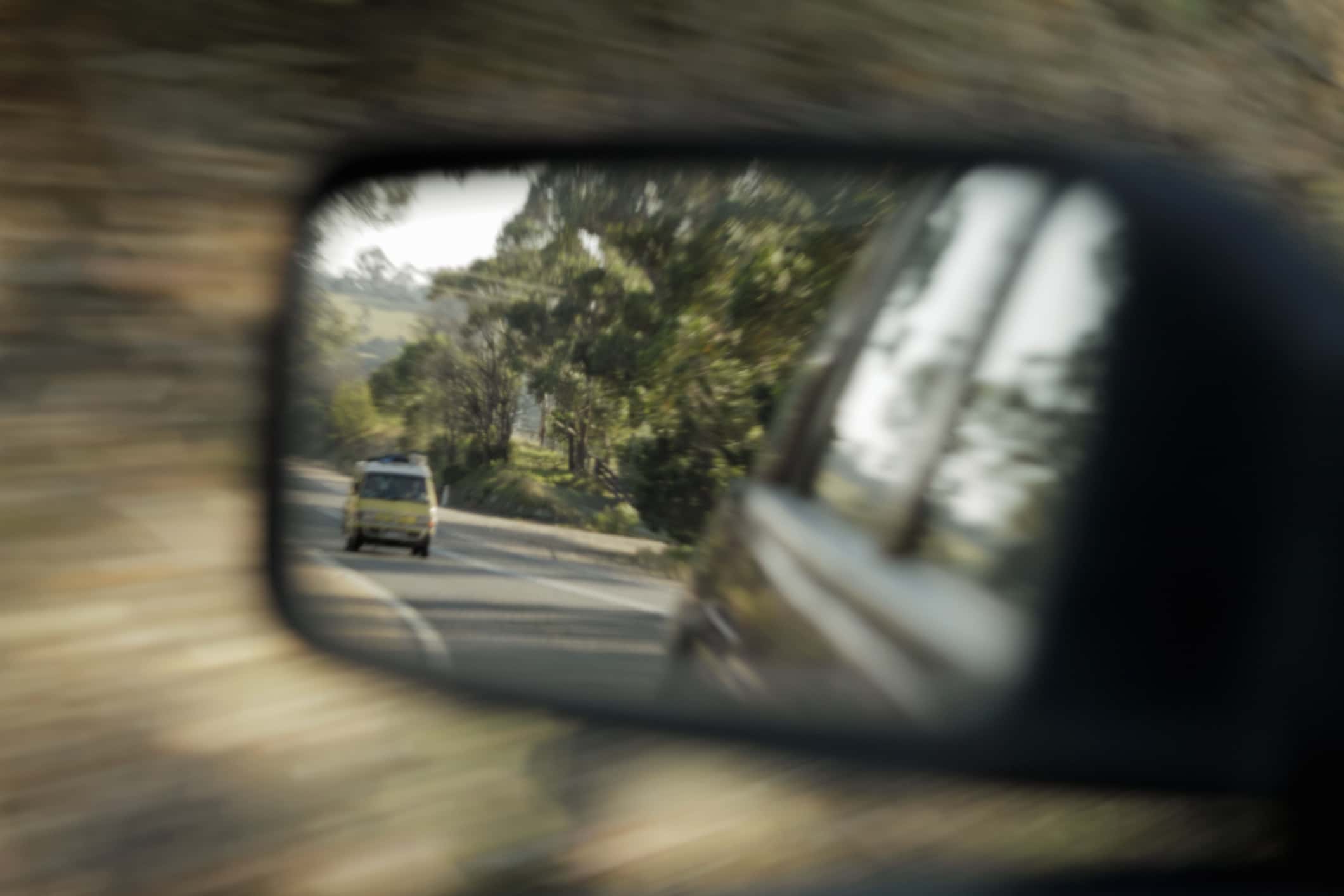 Blurred view of car in side mirror.