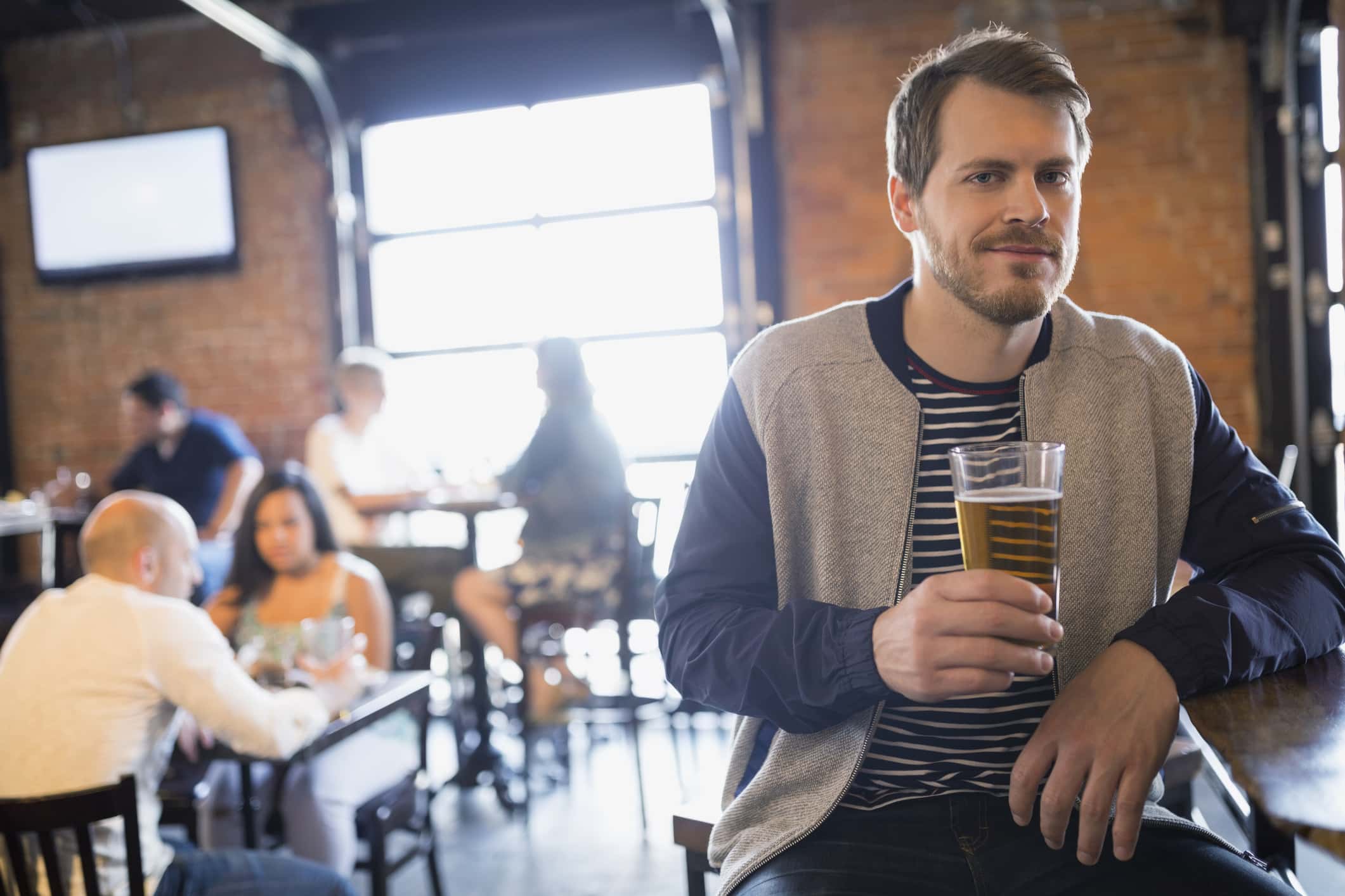 Portrait of man drinking beer in pub.