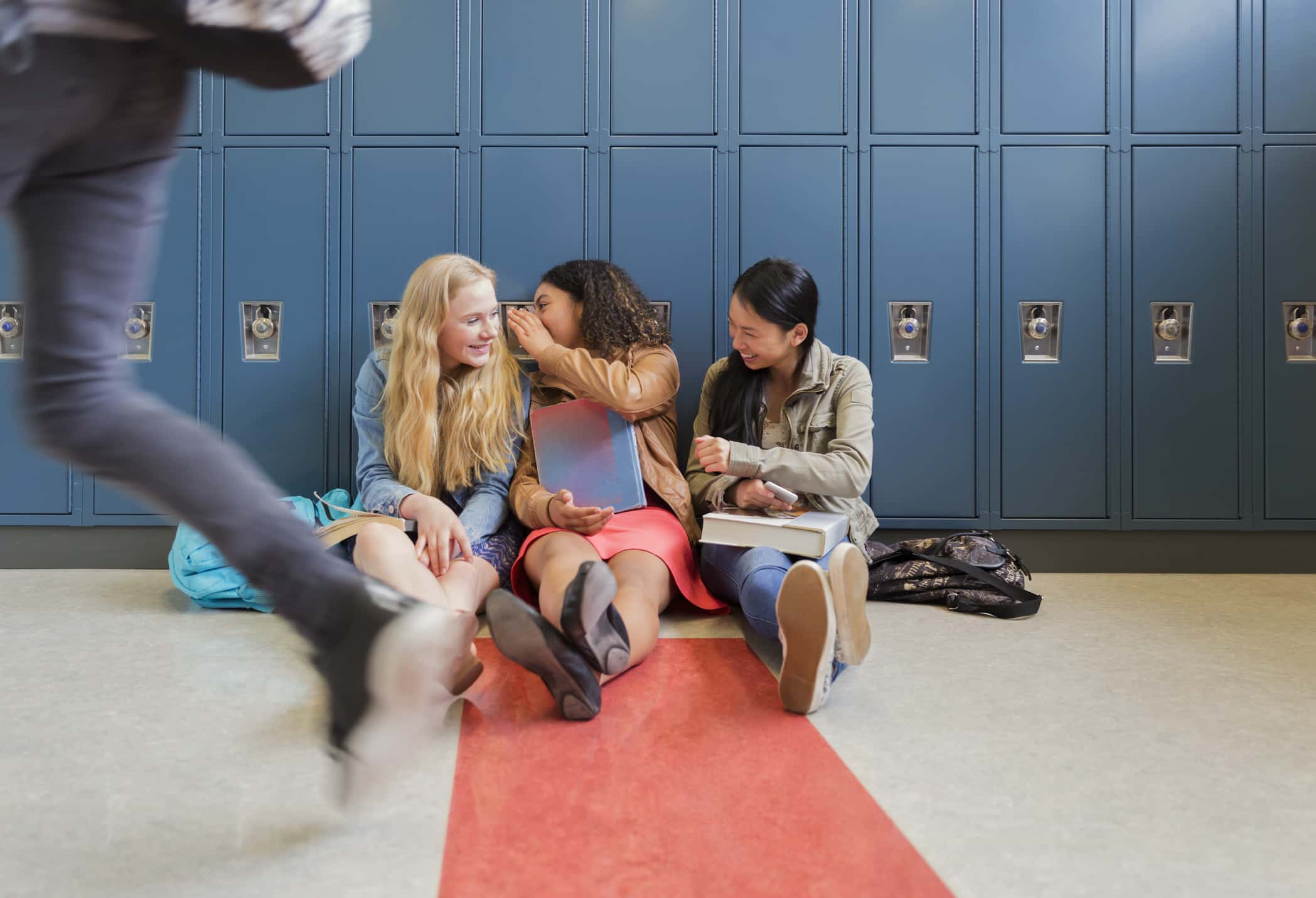 Students gossiping in school hallway.