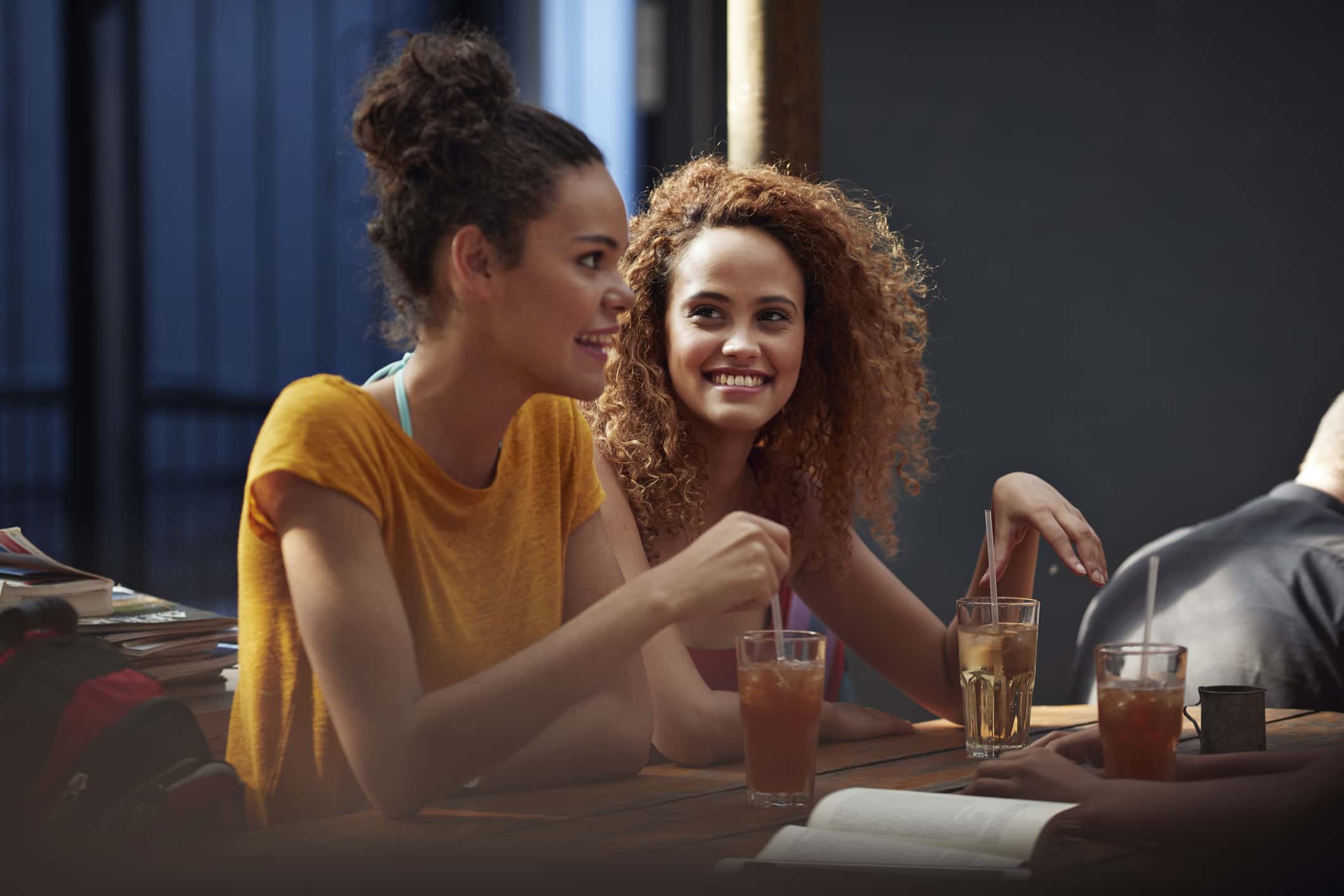 Young women talking and laughing in courtyard of hostel.