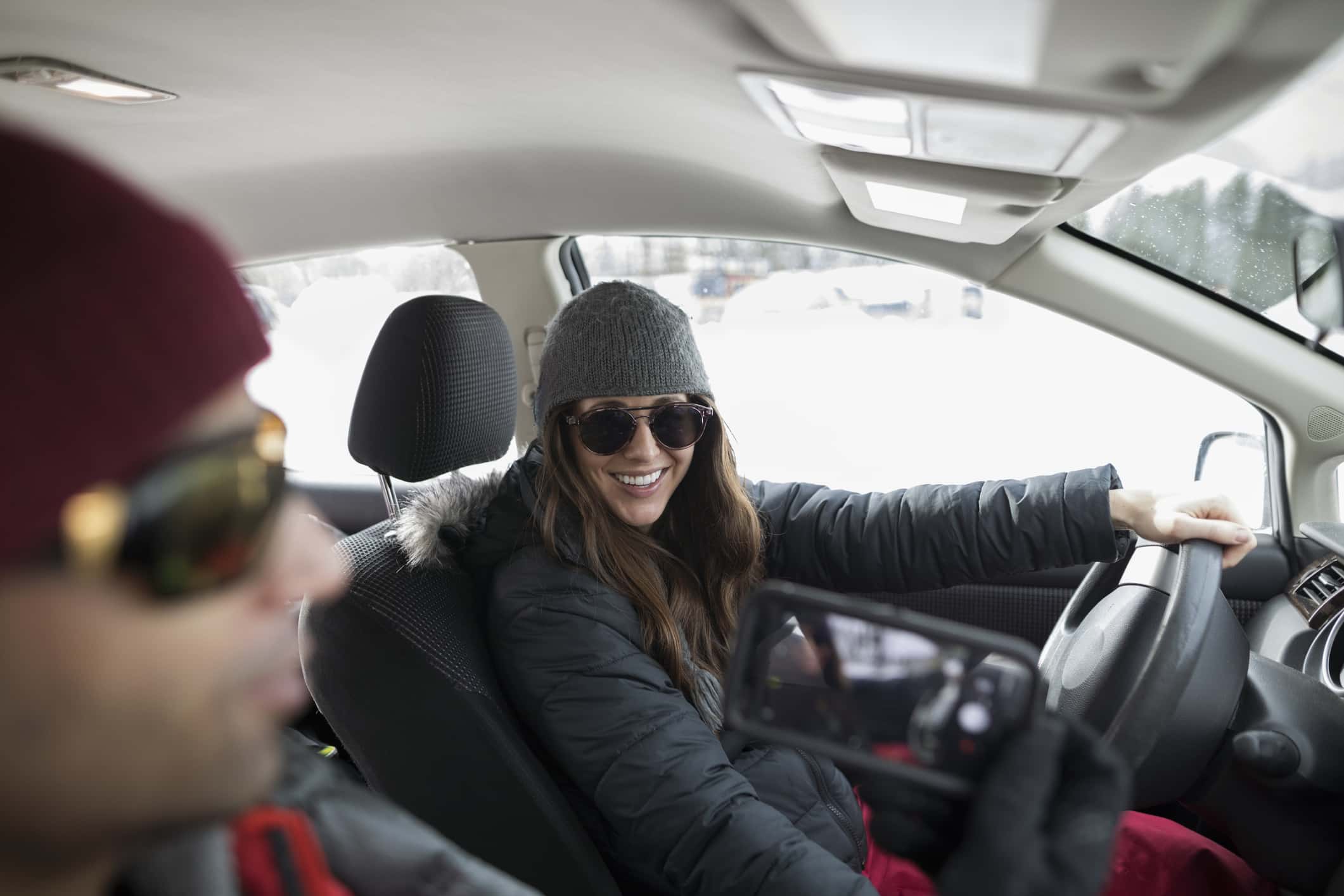 Boyfriend with camera phone photographing girlfriend driving truck.