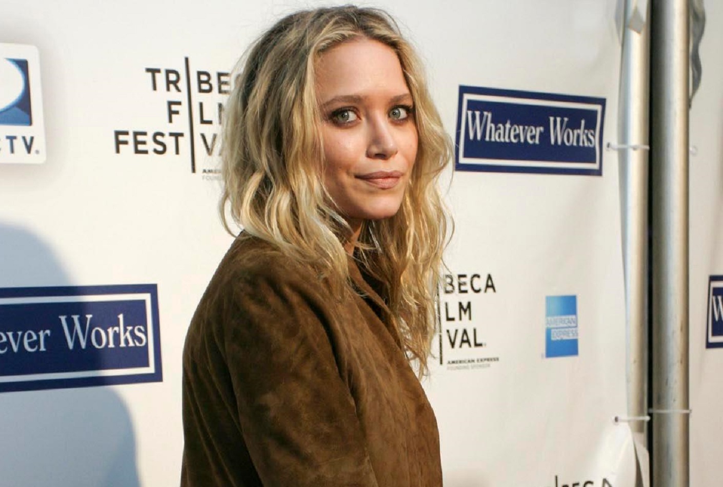 Mary Kate Olsen wearing brown jacket looking at camera