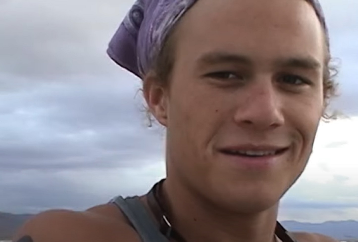 Screenshot: Close up photo of Heath Ledger Wearing purple bandana and smiling
