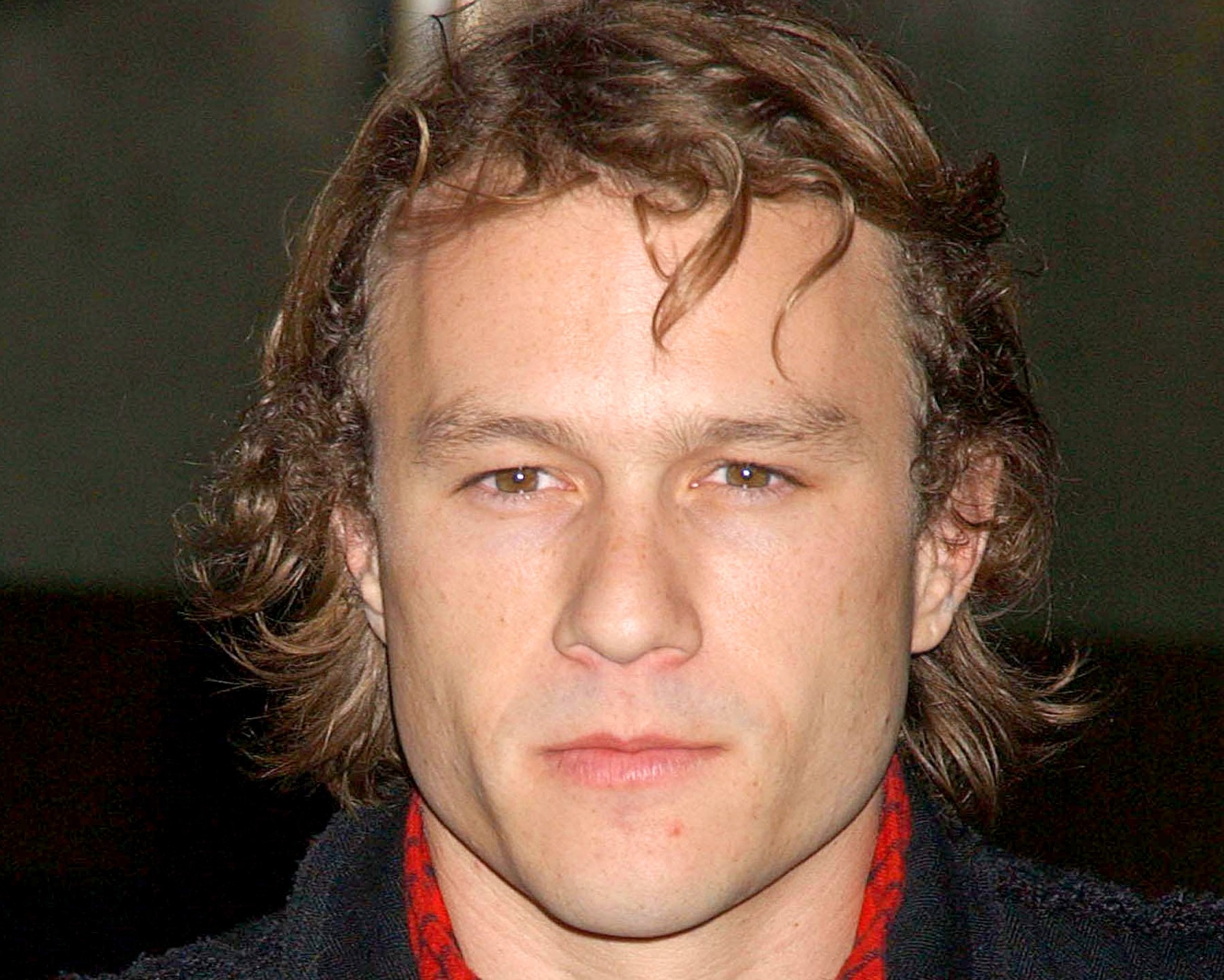 Heath Ledger at CANDY Premiere wearing red shirt and black suit - 2006