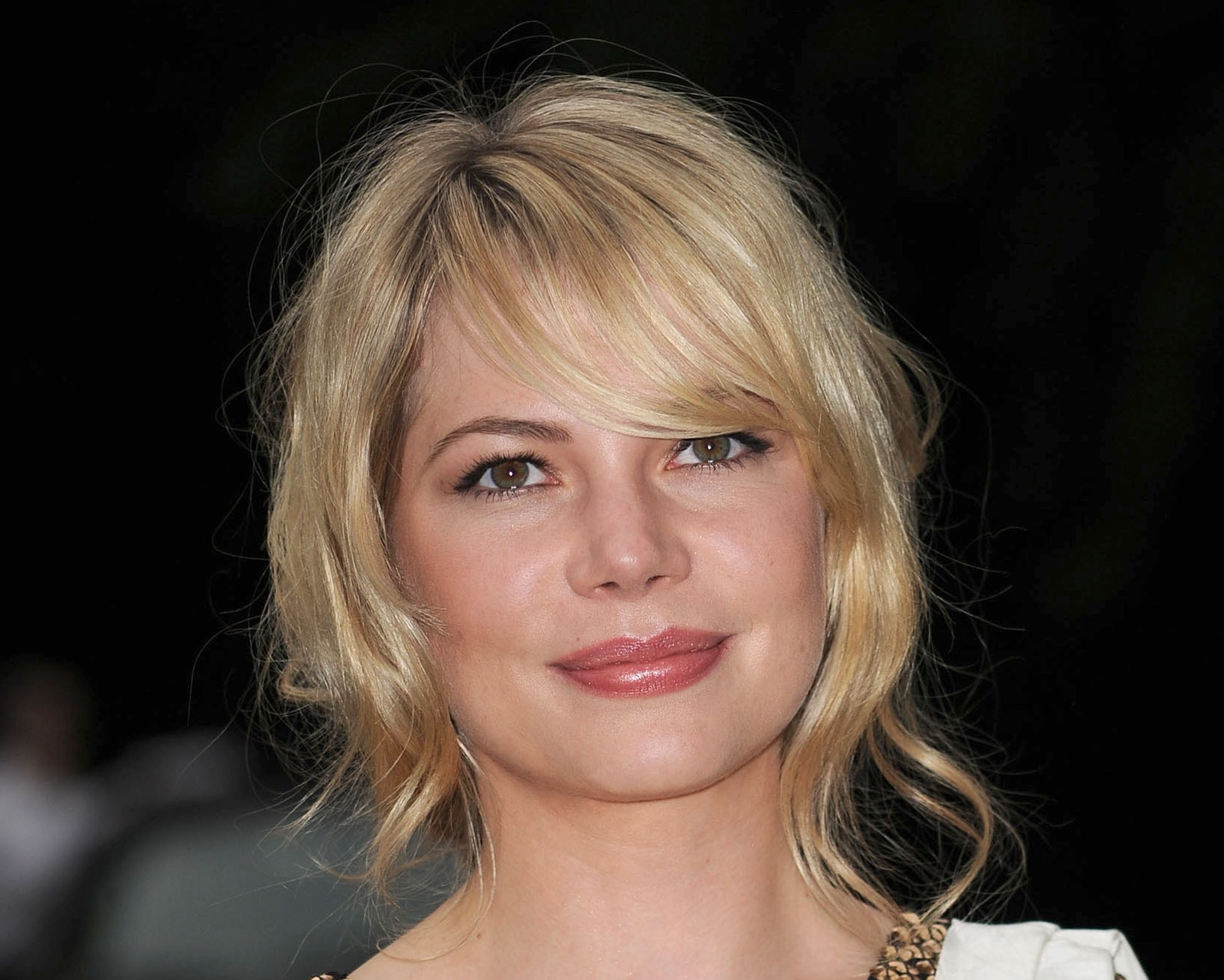 Photo of Michelle Williams in white and gold dress smiling at camera - 2009