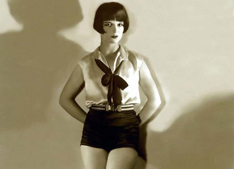 Grayscale Portrait Photo of the actress Louise Brooks, wearing a white shirt, facing the camera