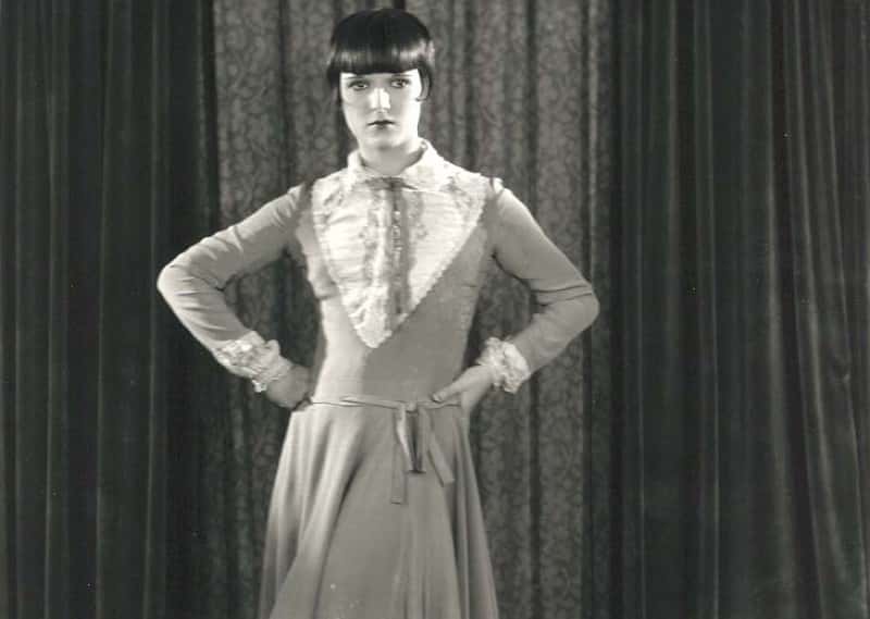 Grayscale Portrait Photo of the actress Louise Brooks, wearing long light colored dress, facing the camera