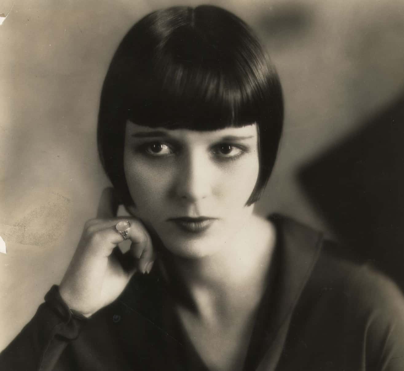 American star of the silent movie era, Louise Brooks, wearing a black dress, facing the camera
