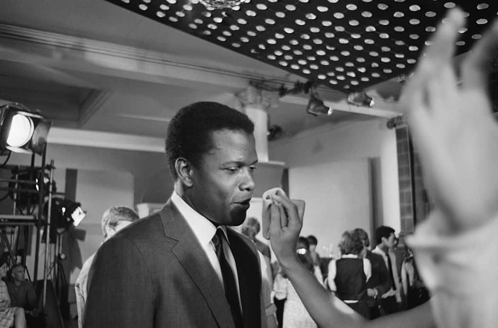 Sidney Poitier has his make-up adjusted on the set of 'To Sir, With Love', directed by James Clavell, 16th June 1966