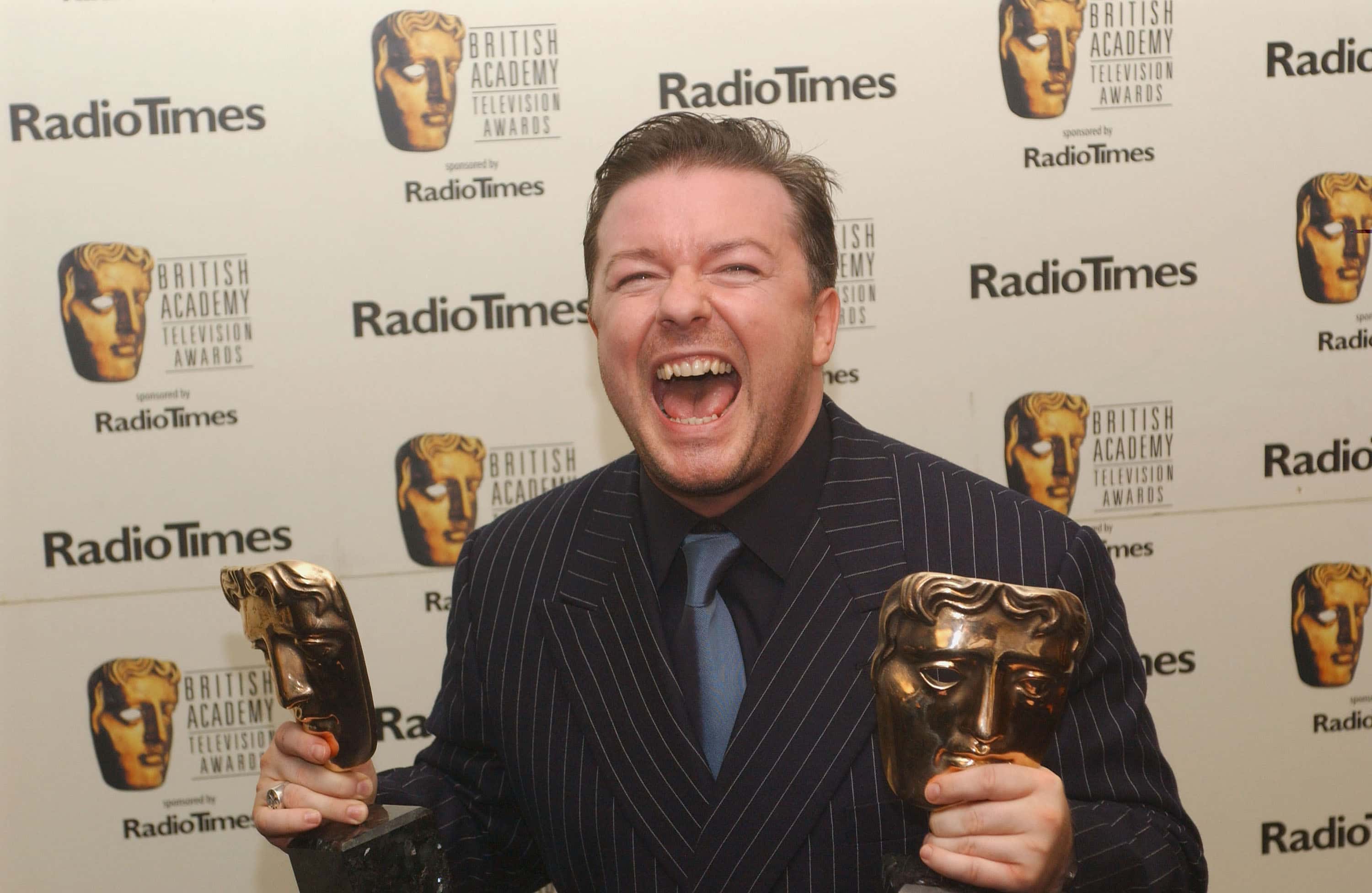 Actor Ricky Gervais poses in the pressroom with awards