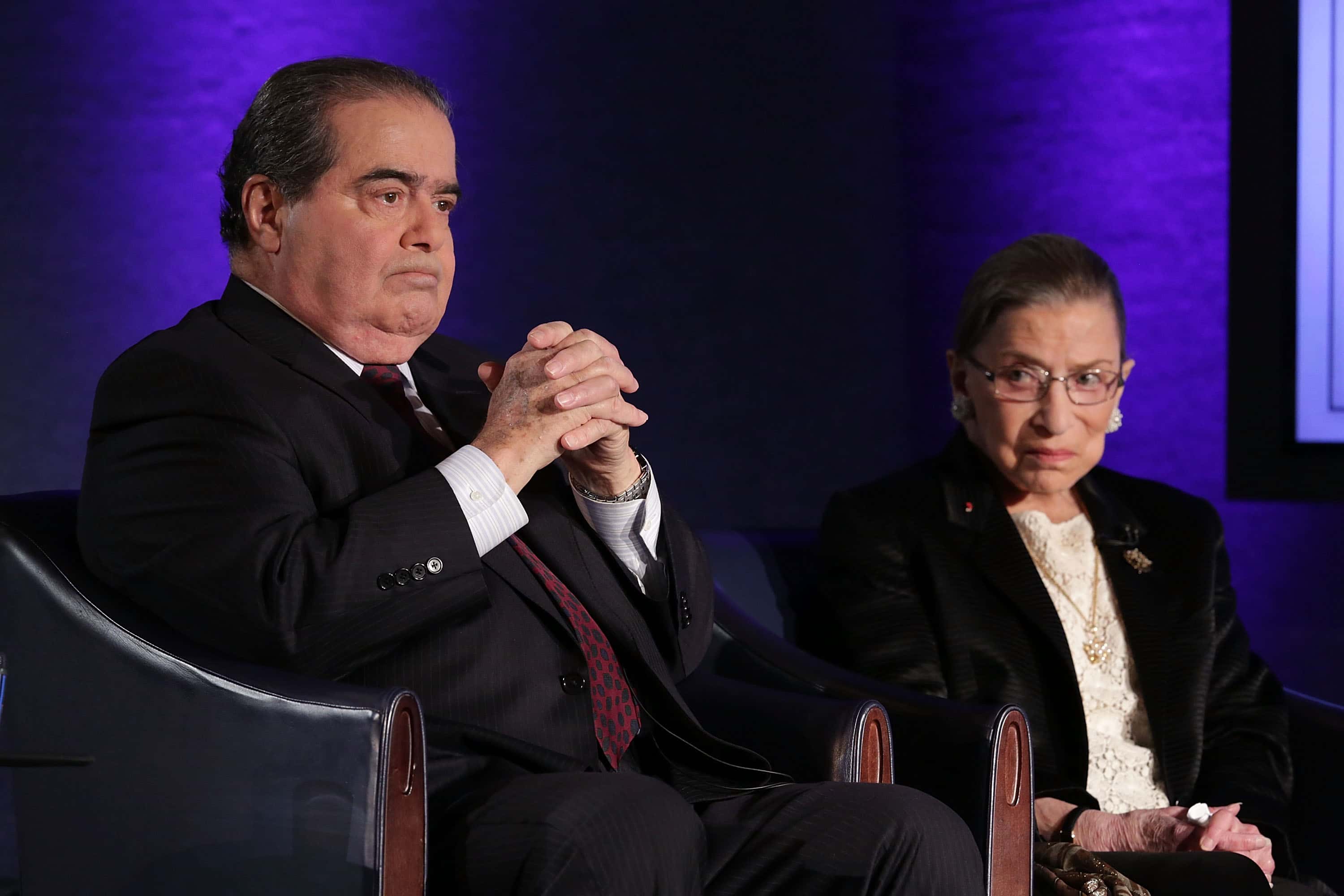 Supreme Court Justices Antonin Scalia (L) and Ruth Bader Ginsburg (R) sitting on armchairs at an event