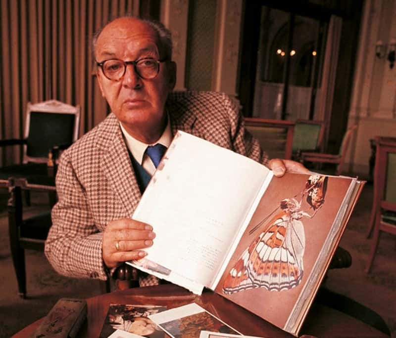 Vladimir Nabokov, Montreux, October 1969 in plaid suit showing a book