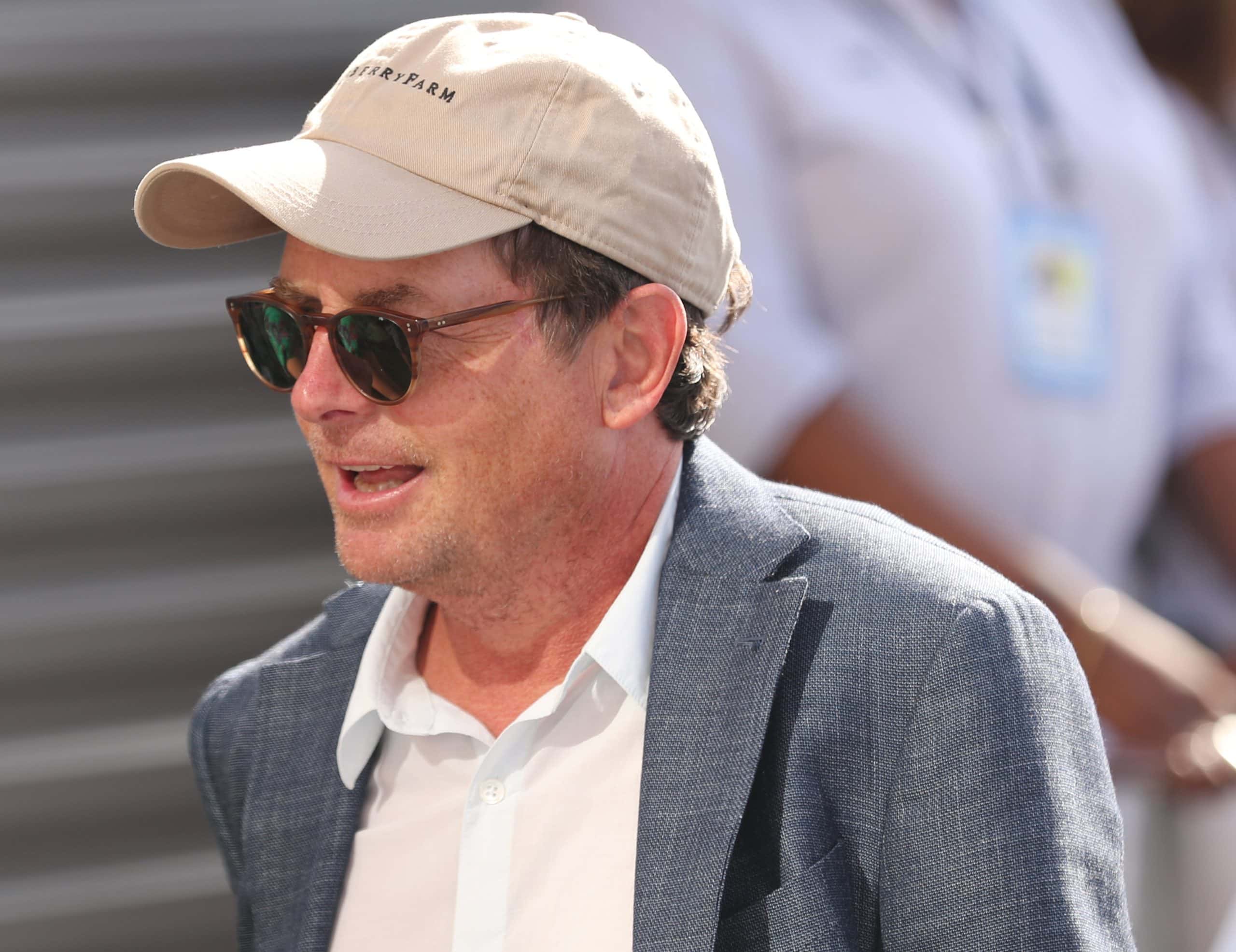Michael J. Fox in gray jacket and hat