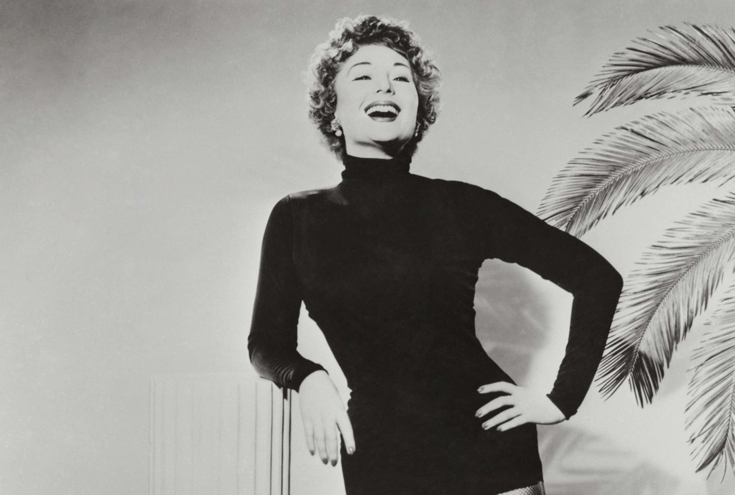 Magda Gabor Leaning on Column Smiling