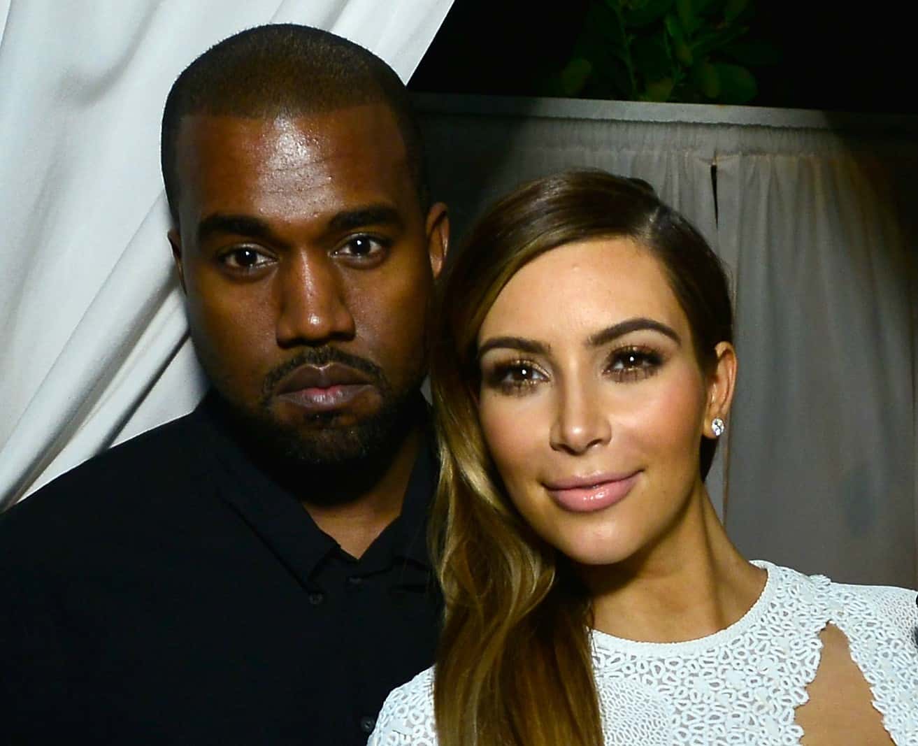 Kanye West in a black shirt and Kim Kardashian in a white top