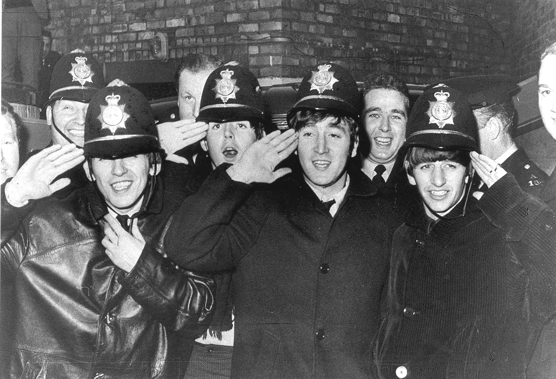 Grayscale Photo of the Pop Group The Beatles dressed as police officers
