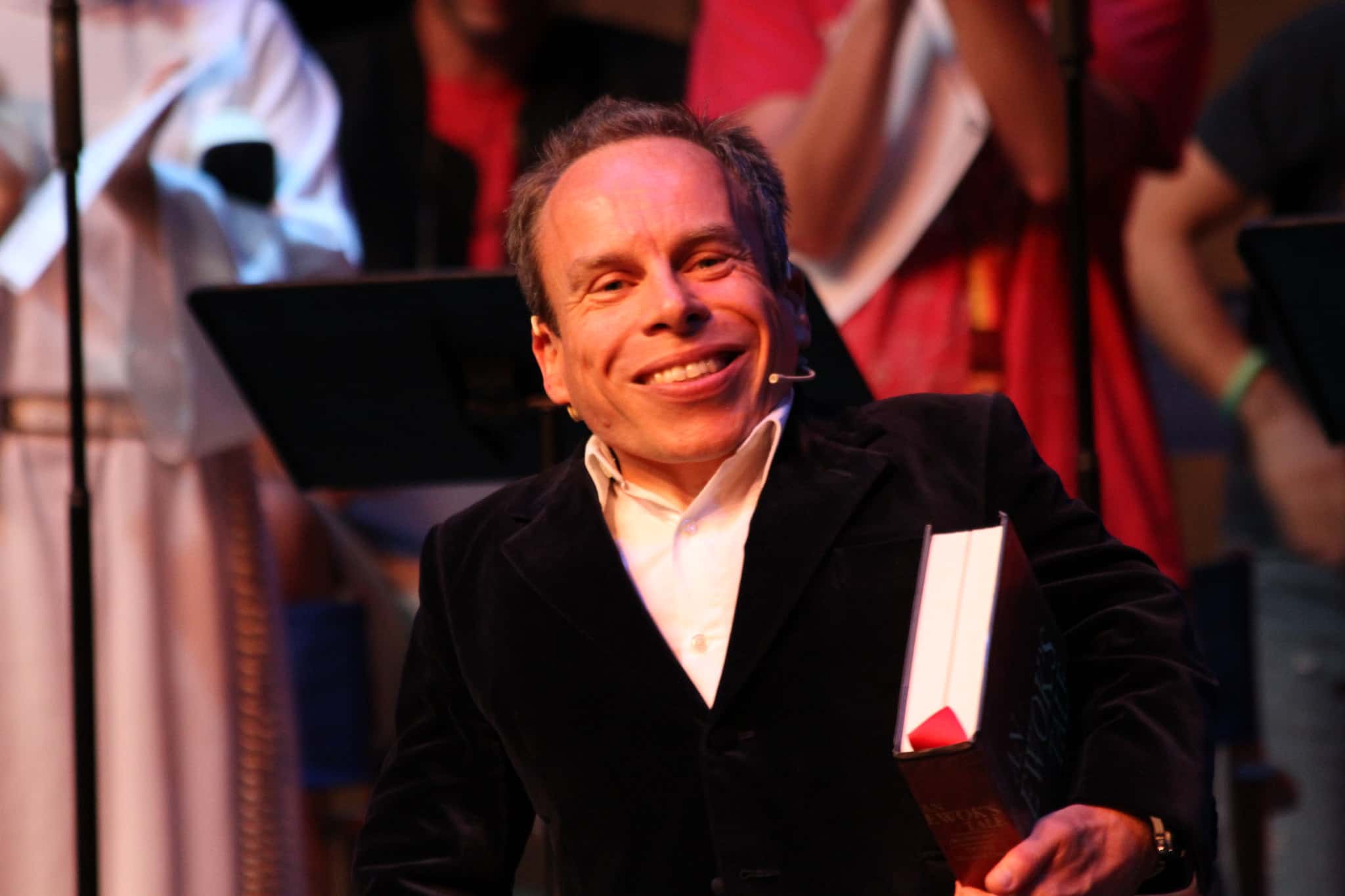 Warwick Davis wearing a black suit