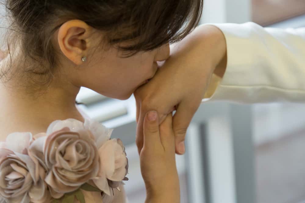 Young Woman wearing a floral dress kisses a hand