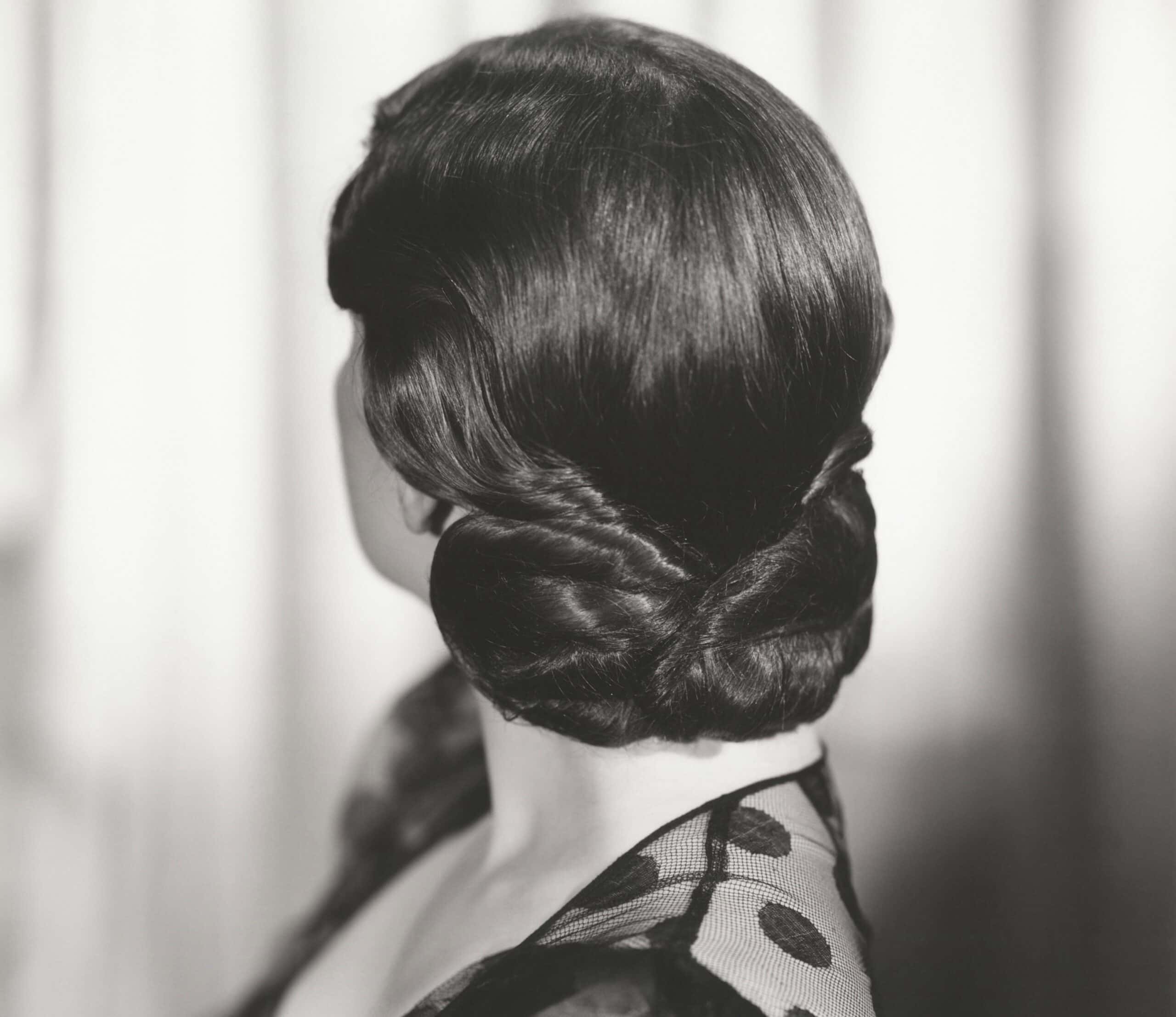 Rear view of woman's 1940s hairstyle wearing a black dress