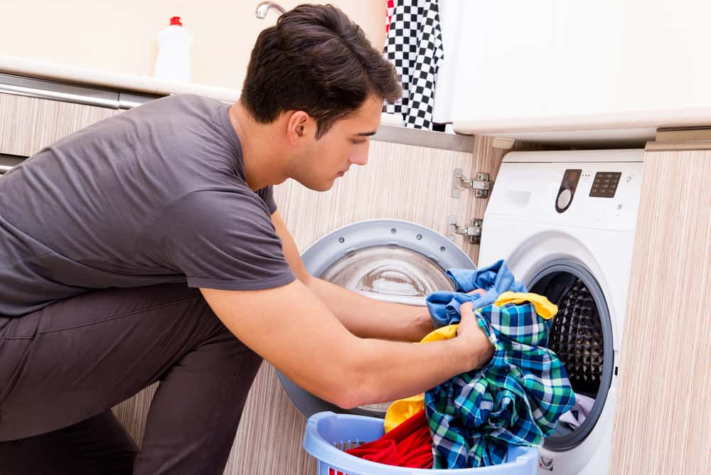 Young husband man doing laundry at home