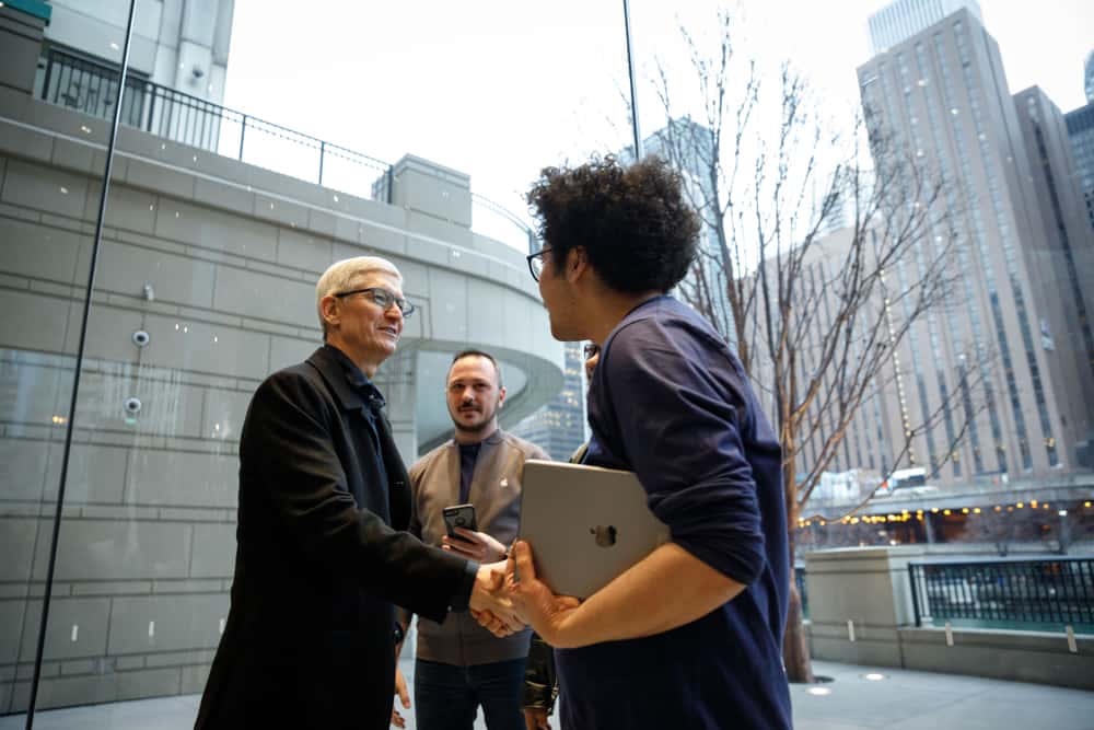 Tim Cook shakes hands with an employee