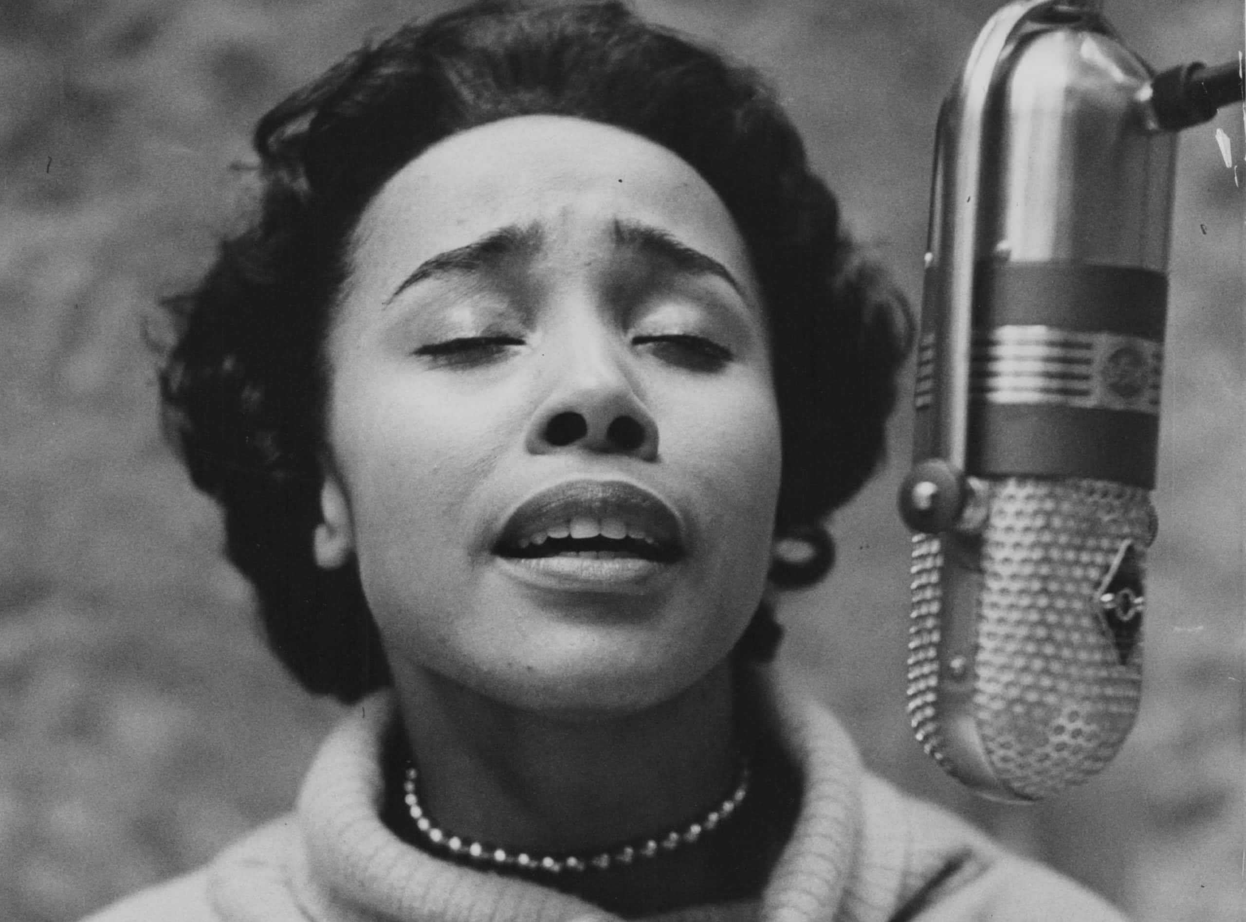 Actress Diahann Carroll singing into a radio microphone