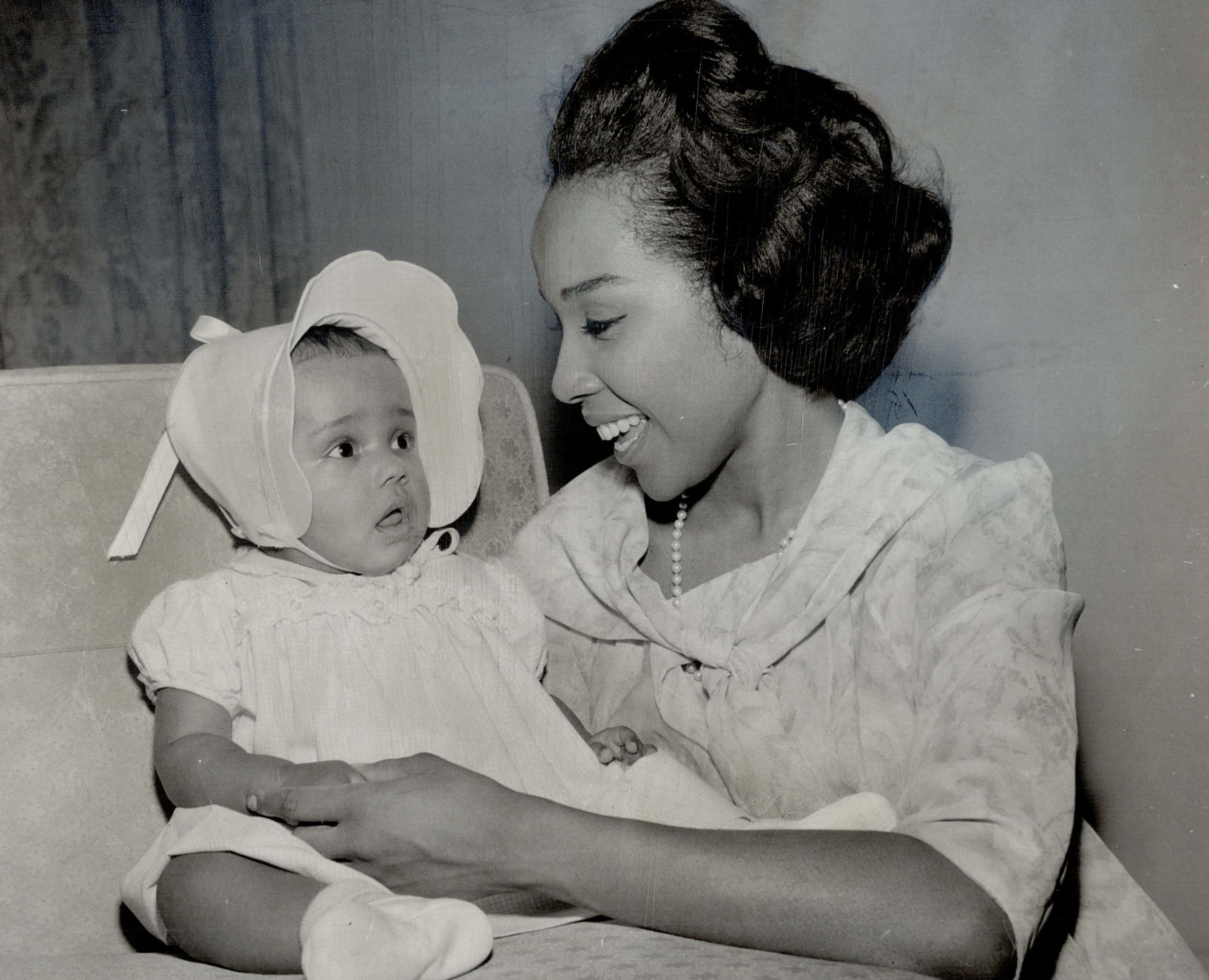 Diahann Carroll and her tiny daughter sitting on a chair facing each other