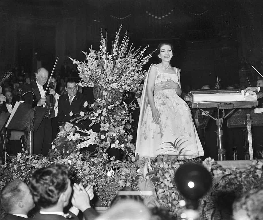 Grayscale Portrait Photo of Maria Callas wearing a white dress, performing on a stage
