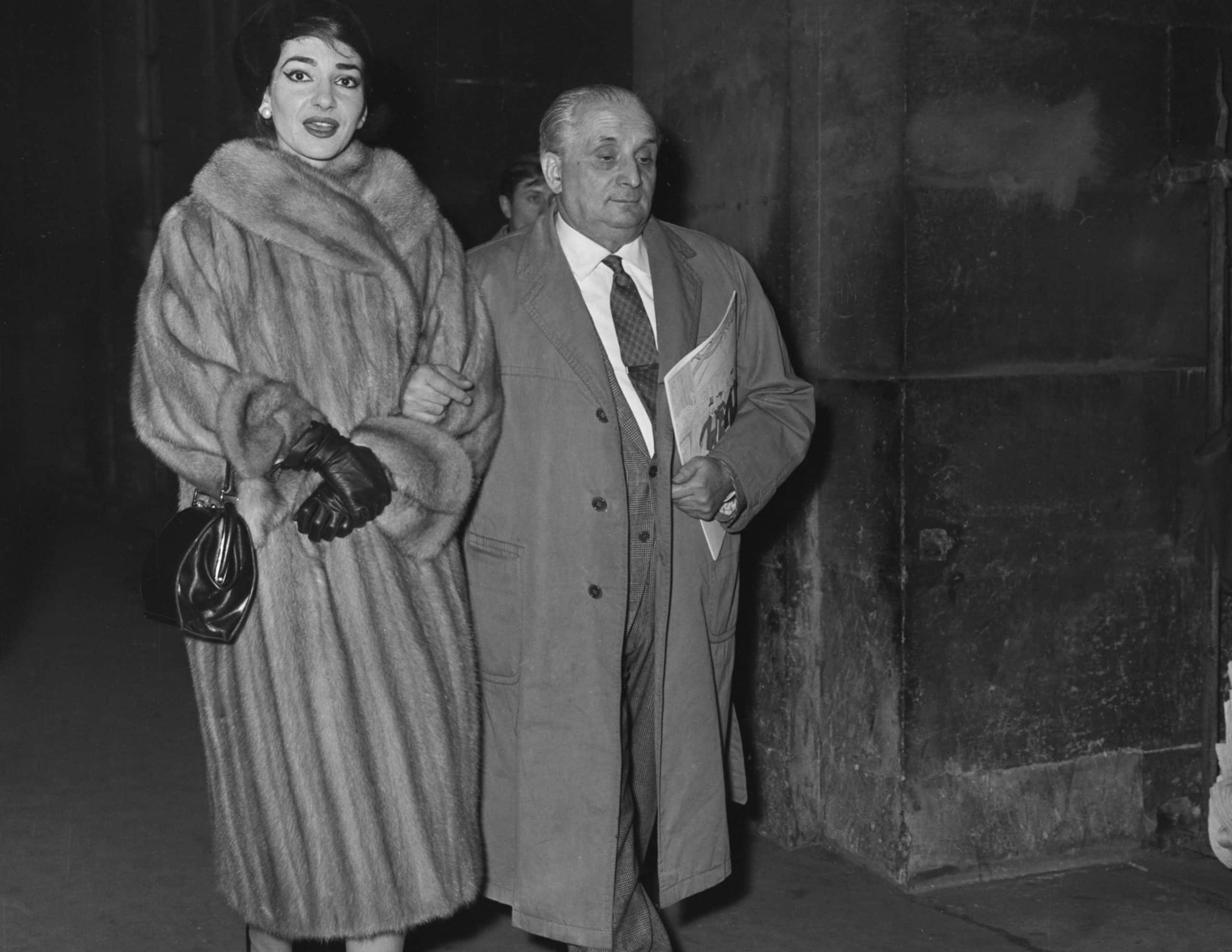 Grayscale Photo of Maria Callas and Giovanni Battista Meneghini, walking hand by hand