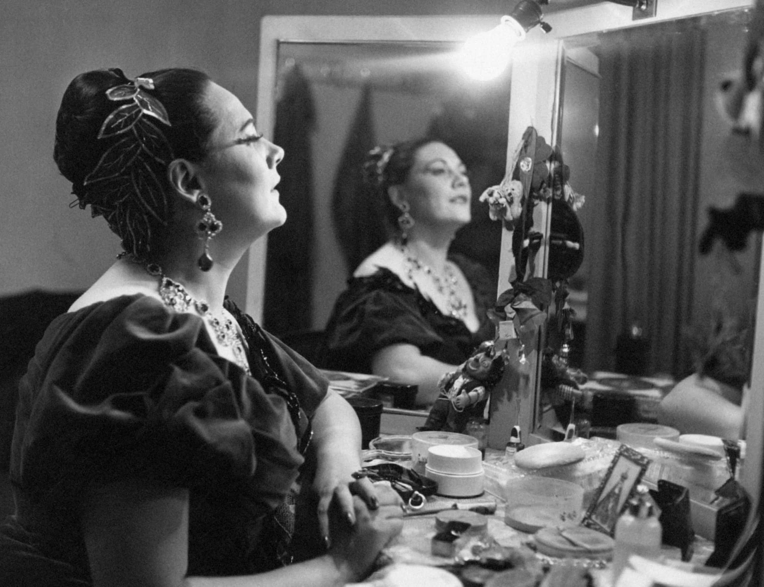Italian soprano Renata Tebaldi posing dressed as Tosca in front of the mirror of her dressing room