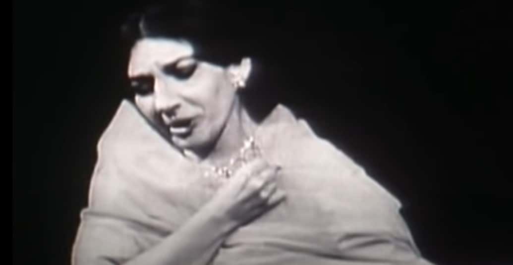 Grayscale Portrait Photo of Maria Callas wearing a white dress, performing on a stage