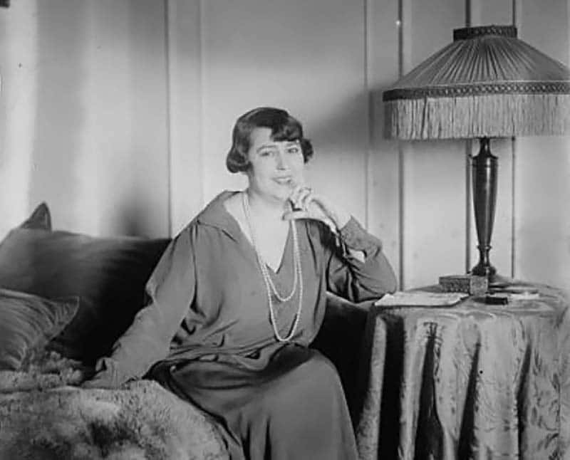 Grayscale Photo of Elvira de Hidalgo, Spanish coloratura soprano singing teacher, sitting on a couch, smiling