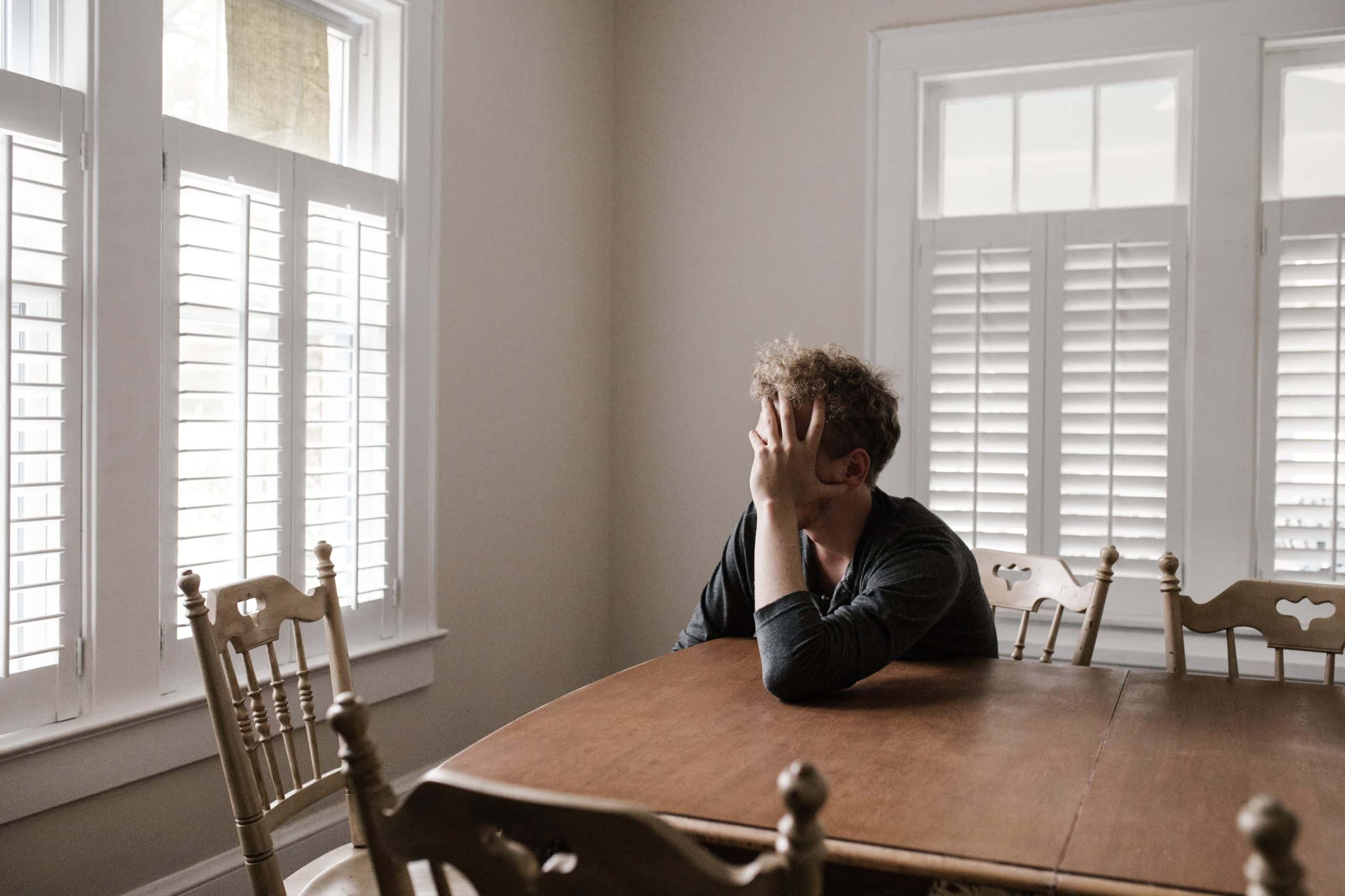 depression, sad man sitting in dining room