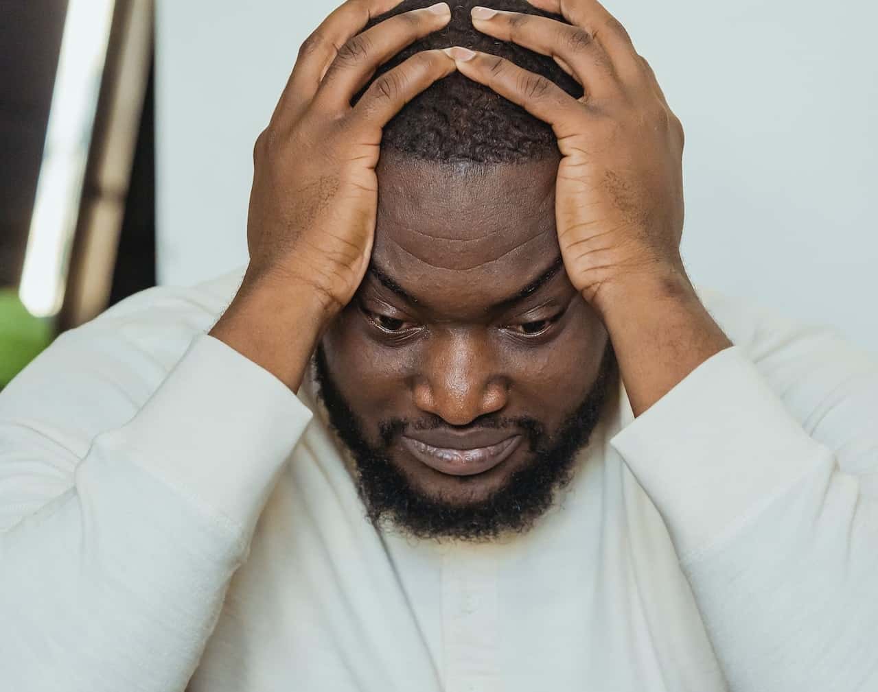 Sad black man with hands on head