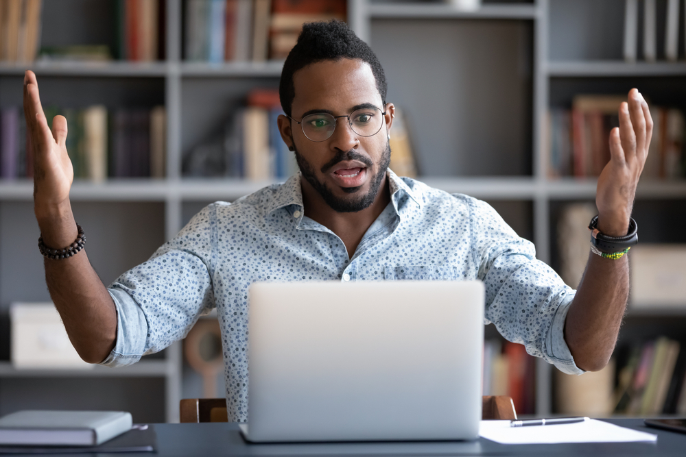 Shocked man working on computer in office.
