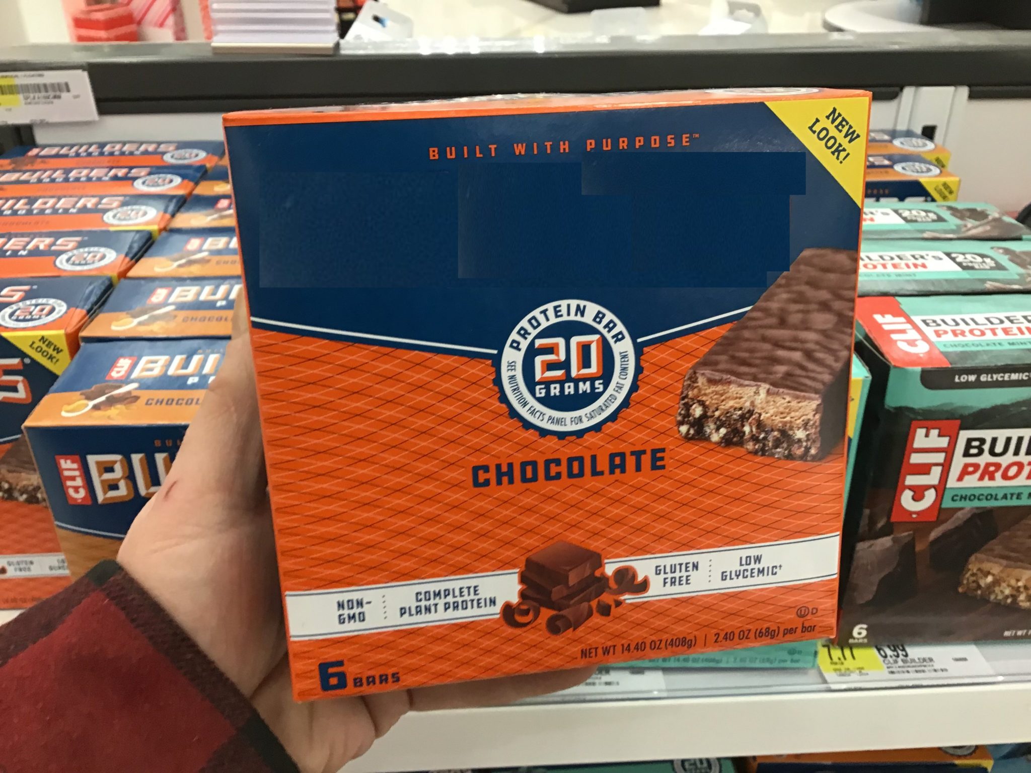 Man holding box of Protein Bar in his hand.