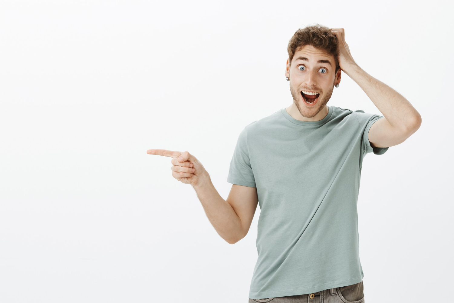 Surprised man wearing light green shirt and pointing.