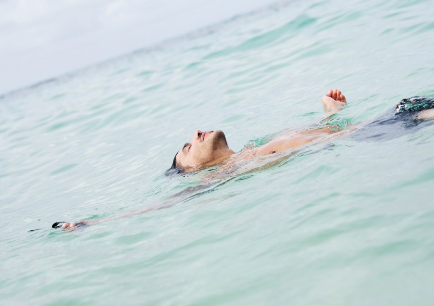 Tired man laying in water