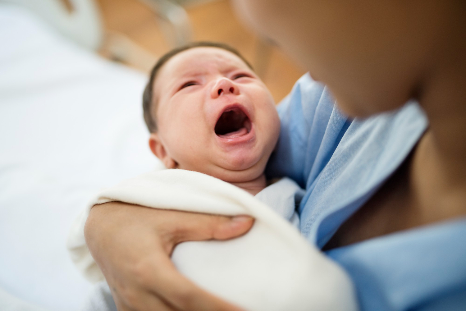 Crying baby in doctor's hands