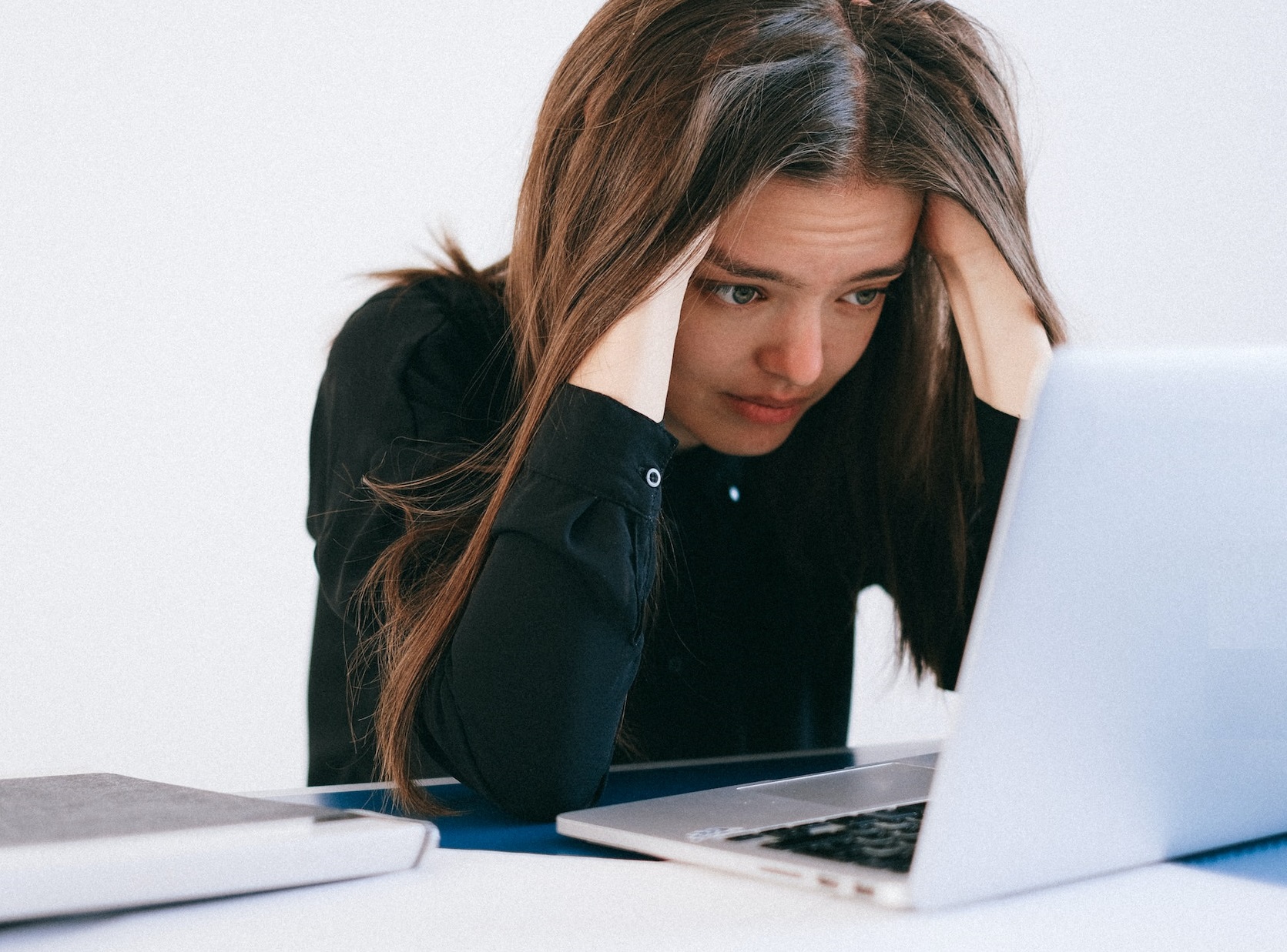 Girl crying over her laptop.