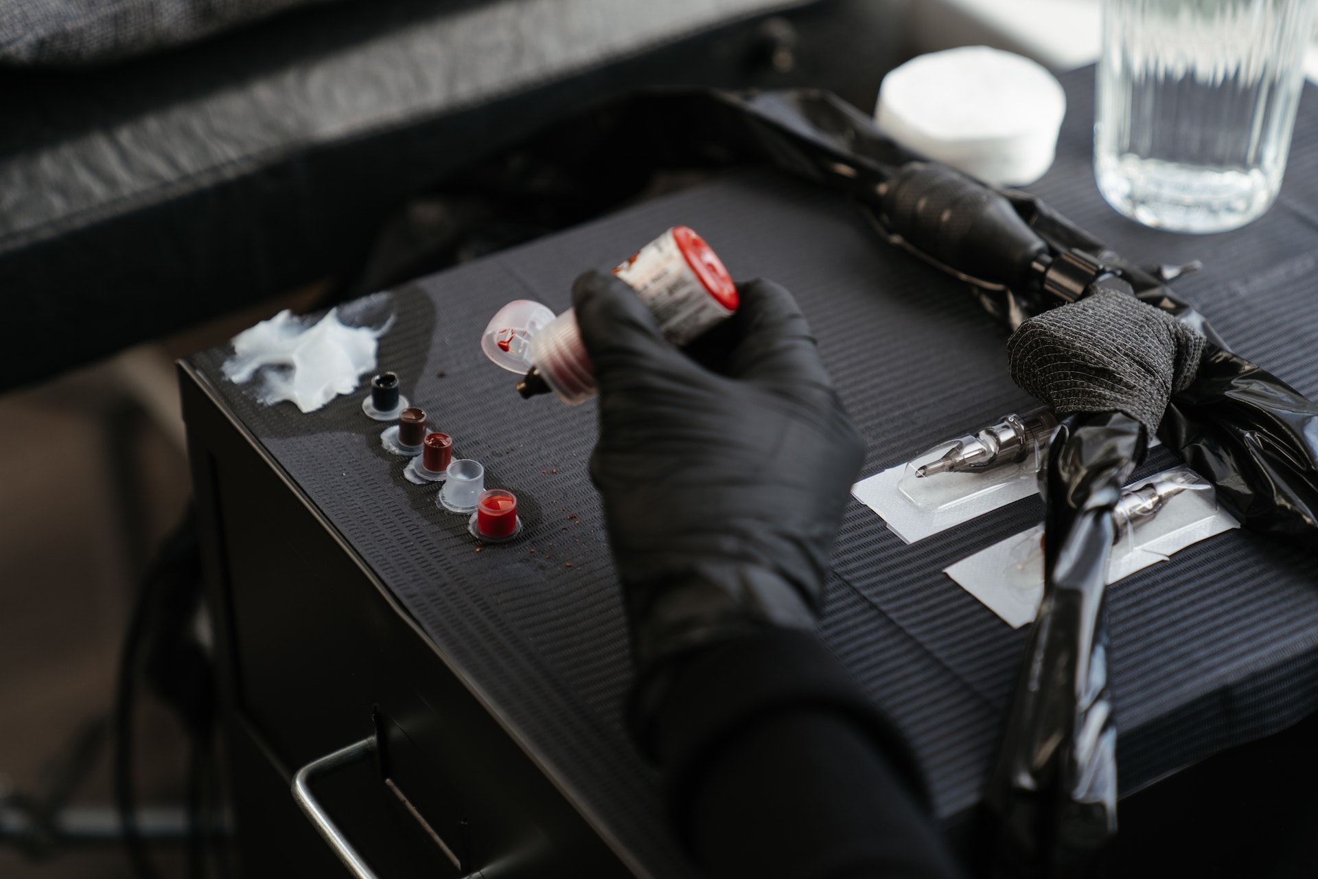 Person with black gloves getting ready to do a tattoo