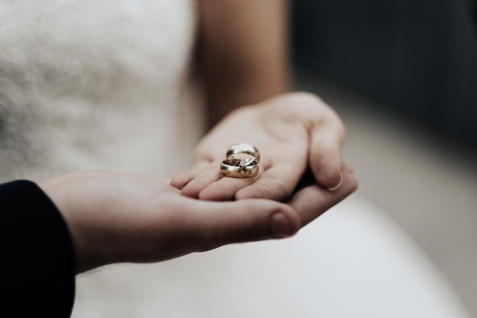 Wedding rings in hands of a bride and groom 
