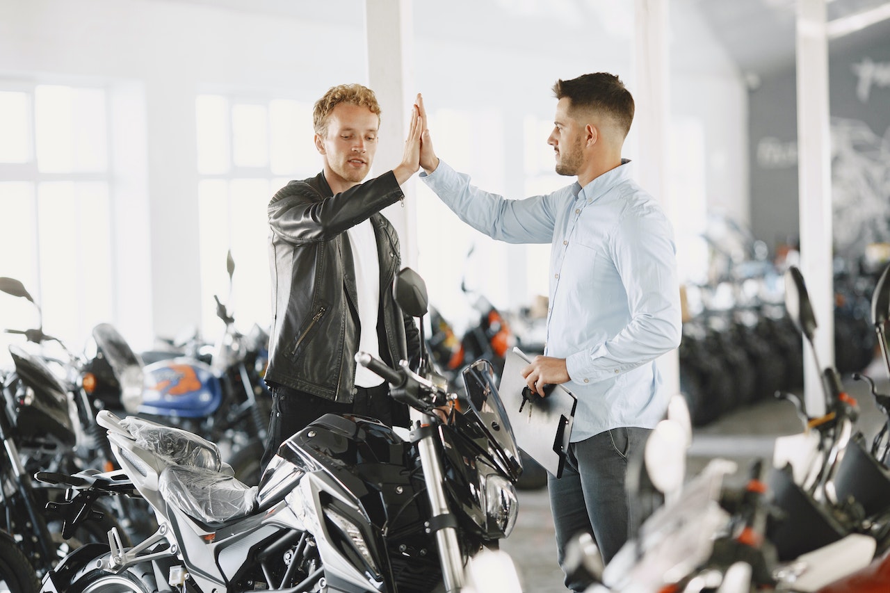 Customer doing high-five with the motor vehicle dealer