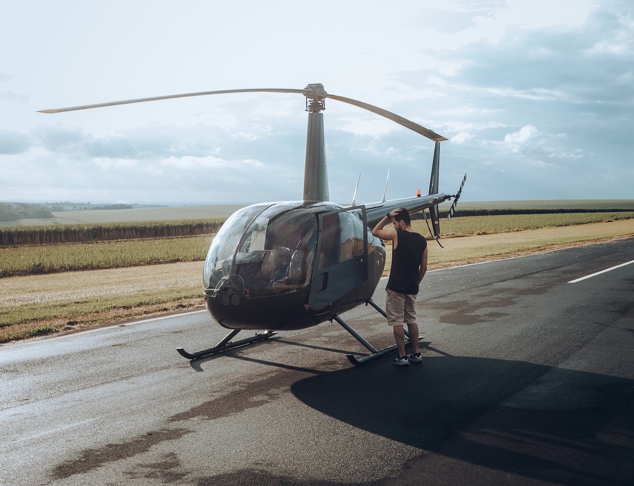 Man standing beside helicopter.