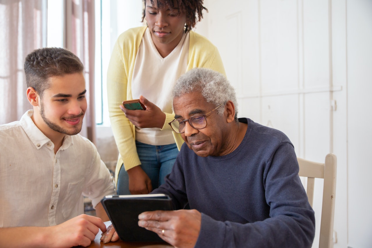 Elder man talking with a young couple.