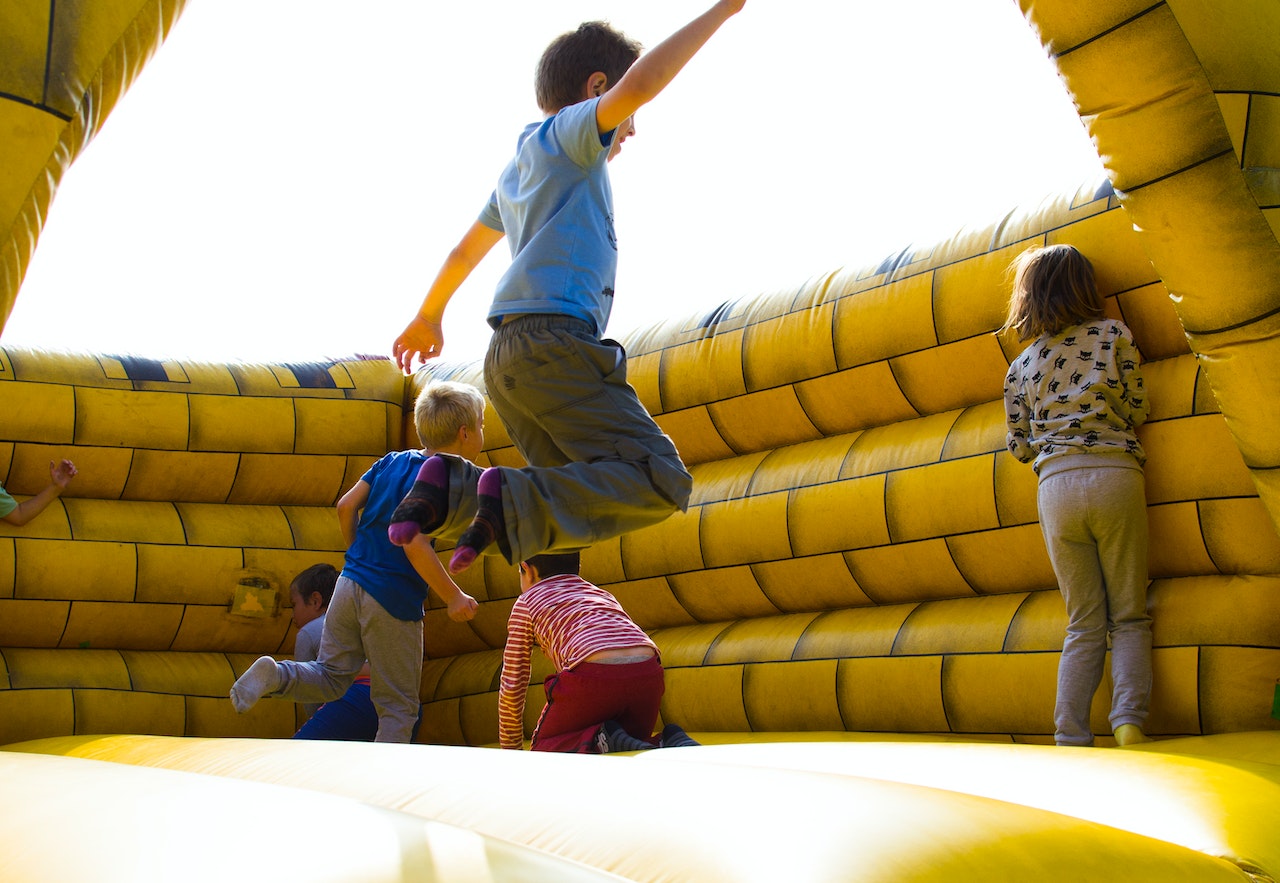 Children jumping in inflatable castle.