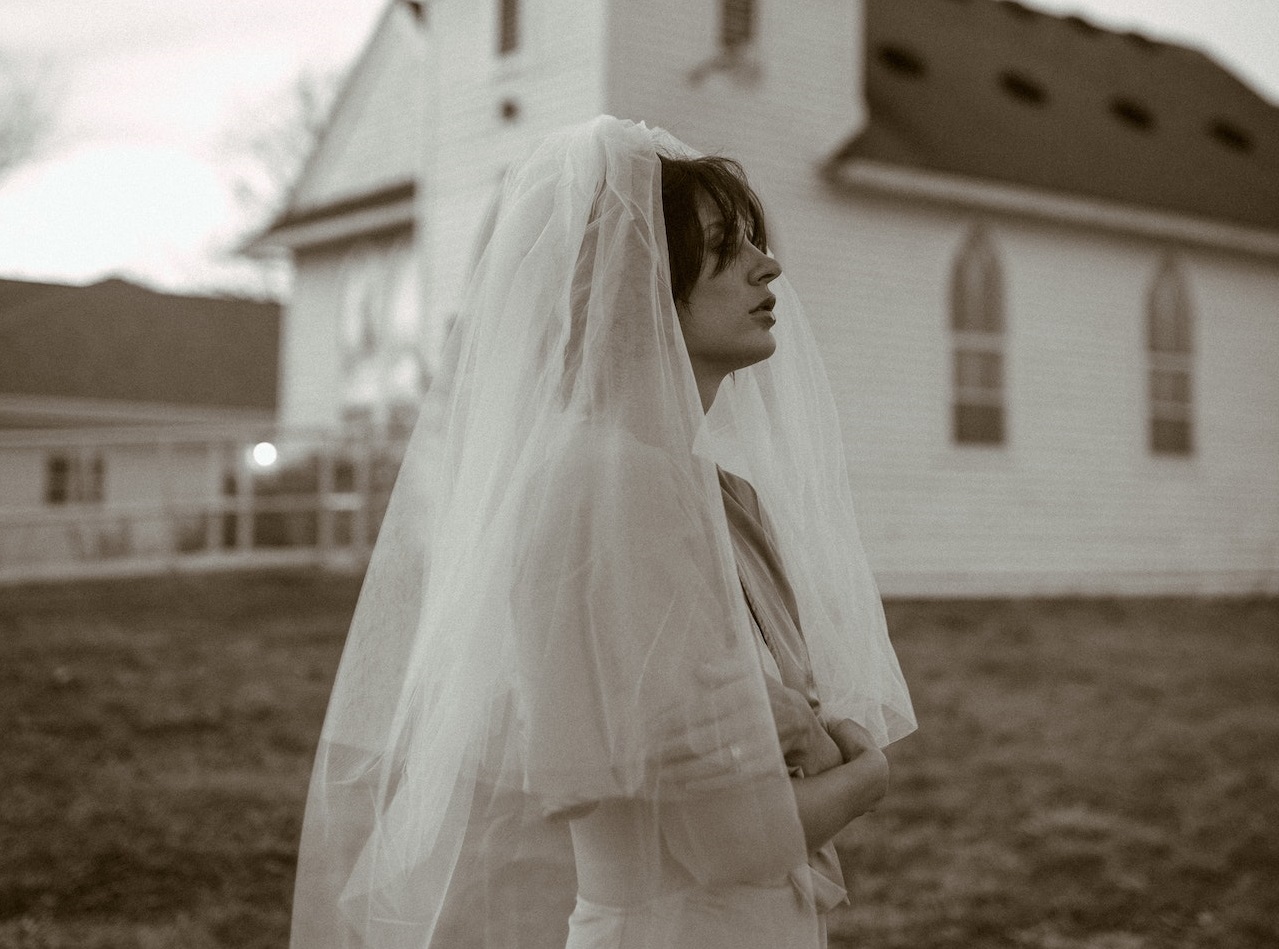 Bride in white dress waiting before church